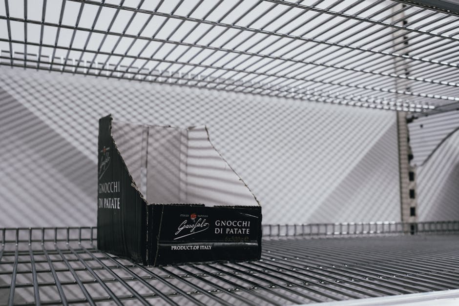 Seorang individu sedang meneliti label kandungan nutrisi pada kemasan makanan instan di rak supermarket untuk menghindari bahan kimia berbahaya.